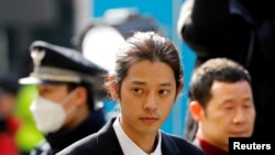 FILE - South Korean singer Jung Joon-young arrives for questioning on accusations of illicitly taping and sharing sex videos on social media, at the Seoul Metropolitan Police Agency in Seoul, South Korea, March 14, 2019.