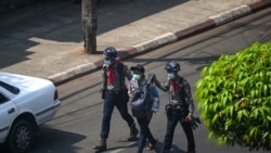 FILE - Police arrest a Myanmar Now journalist in Yangon, February 27, 2021, as protesters were taking part in a demonstration against the military coup.