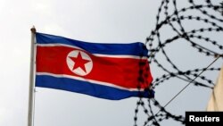 FILE PHOTO: A North Korea flag flutters next to concertina wire at the North Korean embassy in Kuala Lumpur