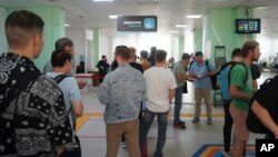 Russian men line up to register at a public service center in Almaty, Kazakhstan, Sept. 27, 2022. After President Vladimir Putin ordered a partial mobilization to bolster his troops in Ukraine, many Russians are leaving their country. (Vladimir Tretyakov//NUR.KZ via AP)