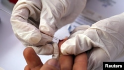  A nurse takes blood for a free HIV test during a HIV prevention campaign marking the World AIDS Day in Lima, Peru Dec. 1, 2016. 