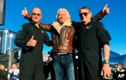 Richard Branson center celebrates with pilots Rick “CJ” Sturckow (L), and Mark “Forger” Stucky (R), after Virgin Galactic’s tourism spaceship climbed more than 50 miles high above California’s Mojave Desert on Dec. 13, 2018.