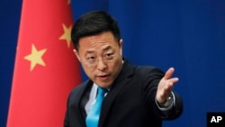 FILE - In this file photo taken Monday, Feb. 24, 2020, Chinese Foreign Ministry new spokesman Zhao Lijian gestures as he speaks during a daily briefing at the Ministry of Foreign Affairs office in Beijing. From Asia to Africa, London to Berlin,…