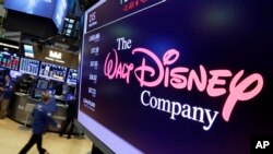 FILE - In this Aug. 8, 2017, file photo, The Walt Disney Co. logo appears on a screen above the floor of the New York Stock Exchange.