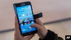 A woman uses an Android smartphone in Brussels on Wednesday April 20, 2016. The European Union is broadening its battle with Google, alleging that the technology giant rigs the global market for mobile apps by making its Android operating system give pref