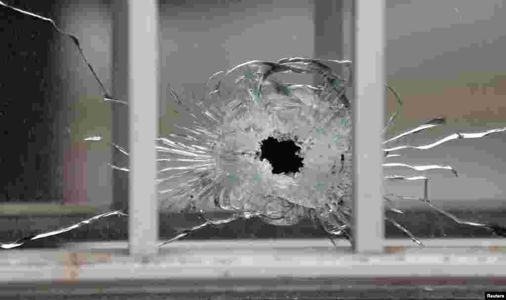 A bullet&#39;s impact is seen on a window at the scene after a shooting at the Paris offices of Charlie Hebdo, a satirical weekly paper, Paris, Jan. 7, 2015.