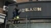 上海一名工人移走商店招牌上的“韩国”两字（2017年3月15日照片）