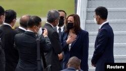 U.S. Vice President Kamala Harris is greeted by Singapore Foreign Minister Vivian Balakrishnan and his delegation, as she arrived at Paya Lebar Air Base in Singapore, Aug. 22, 2021. 