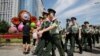  Paramilitary police officers patrol past a flowerbed decoration for the upcoming Forum on China-Africa Cooperation (FOCAC) in Beijing, Aug. 31, 2018.