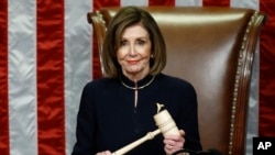House Speaker Nancy Pelosi of Calif., smiles as she holds the gavel as the House votes on articles of impeachment against President Donald Trump by the House of Representatives at the Capitol in Washington, Dec. 18, 2019.