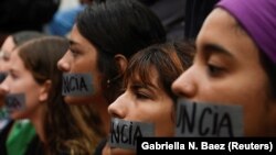 A group of women hold a silent protest with "Resign" covering their mouths with tape during the seventh day of protest calling for the resignation of Governor Ricardo Rossello in San Juan, Puerto Rico July 19, 2019.