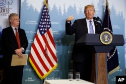 National Security Adviser John Bolton looks on as President Donald Trump speaks during a news conference at the G-7 summit, June 9, 2018, in La Malbaie, Quebec, Canada.
