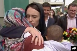 In this image made from video, New Zealand's Prime Minister Jacinda Ardern, center, hugs and consoles a woman as she visited Kilbirnie Mosque to lay flowers among tributes to Christchurch attack victims, in Wellington, March 17, 2019.