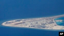 FILE - an airstrip, structures and buildings on China's man-made Subi Reef in the Spratly chain of islands in the South China Sea are seen from a Philippine Air Force C-130 transport plane of the Philippine Air Force.