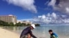 关岛海滨风光如画，碧水金沙。居民仁川健司与他的儿子秀树在关岛的海滩玩耍（2017年8月14日）。仁川健司知道朝鲜的威胁，但不怎么担心。他说，朝鲜的导弹会落在水里，而不是关岛。&nbsp;