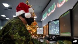 เจ้าหน้าที่ NORAD พูดคุยกับปลายสายที่ติดตามซานต้า (Sable Brown/NORAD via AP)