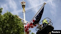 Workers hang a U.S. flag on The Mall towards Buckingham Palace in central London ahead of U.S. President Donald Trump state visit to Britain, June 2, 2019.