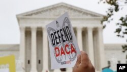 FILE - In this Nov. 12, 2019, photo, people rally outside the Supreme Court. The Trump administration must accept new applications for the DACA program that protects some young immigrants from deportation, a federal judge ruled Dec. 4, 2020.