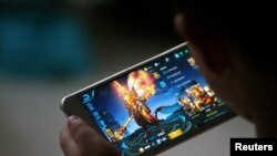 FILE - A child plays the game Honour of Kings by Tencent at home in Dezhou, Shandong province, China, July 2, 2017. 