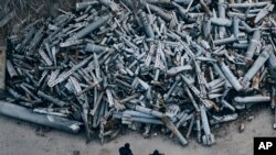 Police officers look at collected fragments of the Russian rockets that hit Kharkiv, in Kharkiv, Ukraine, Saturday, Dec. 3, 2022. (AP Photo/Libkos)