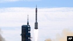 FILE - A Long March-2F Y12 rocket carrying a crew of Chinese astronauts in a Shenzhou-12 spaceship lifts off at the Jiuquan Satellite Launch Center in Jiuquan, China, June 17, 2021.