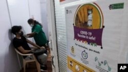 A health worker administers the COVISHIELD vaccine for COVID-19 at a vaccination center in Mumbai, India, Monday, May 3, 2021. (AP Photo/Rafiq Maqbool)