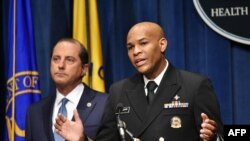 U.S. Surgeon General, Vice Admiral Jerome Adams, flanked by Health and Human Services Secretary Alex Azar, briefs the media on the release of a warning against marijuana use by by adolescents and pregnant women, in Washington, Aug. 29, 2019. 