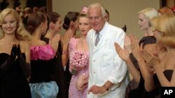 French designer Hubert de Givenchy, seen in this July 1995 photo, is applauded by his models after his 1995-96 fall-winter haute couture fashion collection in Paris. French couturier Hubert de Givenchy, a pioneer of ready-to-wear who designed Audrey Hepburn's little black dress in "Breakfast at Tiffany's," has died at the age of 91. 