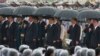 中共总书记习近平、中国总理李克强、中共政治局常委张德江、俞正声、王岐山等人在雨中在人民英雄纪念碑前唱国歌（2013年10月1日）
