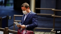Luxembourg's Prime Minister Xavier Bettel waits for his car as he leaves the European Council building in the early morning during an EU summit in Brussels, Monday, July 20, 2020. Leaders from 27 European Union nations met throughout the night…