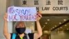 64岁的香港抗争者王凤瑶，人称王婆婆，因为参与去年反送中运动游行示威，在深圳被关押、软禁14个月。10月27日王凤瑶再次在香港上街示威。她手持标语在东区法院大楼外呼吁拯救香港年青人(美国之音/汤惠芸）