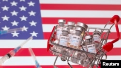 A small shopping basket filled with vials labeled "COVID-19 - Coronavirus Vaccine" and medical syringes are placed on a U.S. flag in this illustration taken November 29, 2020. Picture taken November 29, 2020. REUTERS/Dado Ruvic/Ilustration