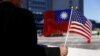 FILE - A demonstrator holds flags of Taiwan and the United States in support of Taiwanese President Tsai Ing-wen during an stopover after her visit to Latin America in Burlingame, Calif., Jan. 14, 2017.