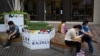 北京的一条商业街上的商店门口站着一名向往张望的销售员。（2021年9月15日）