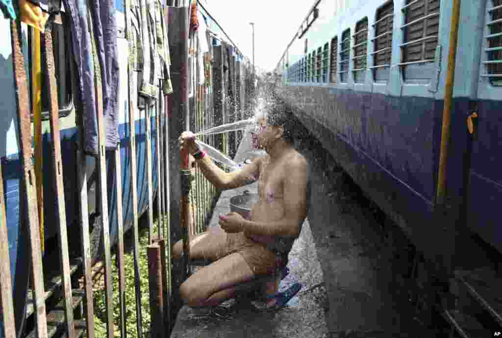 An Indian passenger takes a bath at a railway station during a severe heat wave where temperatures have reached 48 degrees Celsius, in Jammu, May 25, 2015.&nbsp;