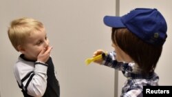 Harrison, 5, who is autistic, plays with Kaspar, a child-sized humanoid robot developed at the University of Hertfordshire to interact and help improve the lives of children with autism, in Stevenage, Britain, Jan. 30, 2017.