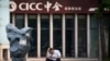 2015年7月7日一名男子揉着头在中金证卷公司外浏览他的智能手机。